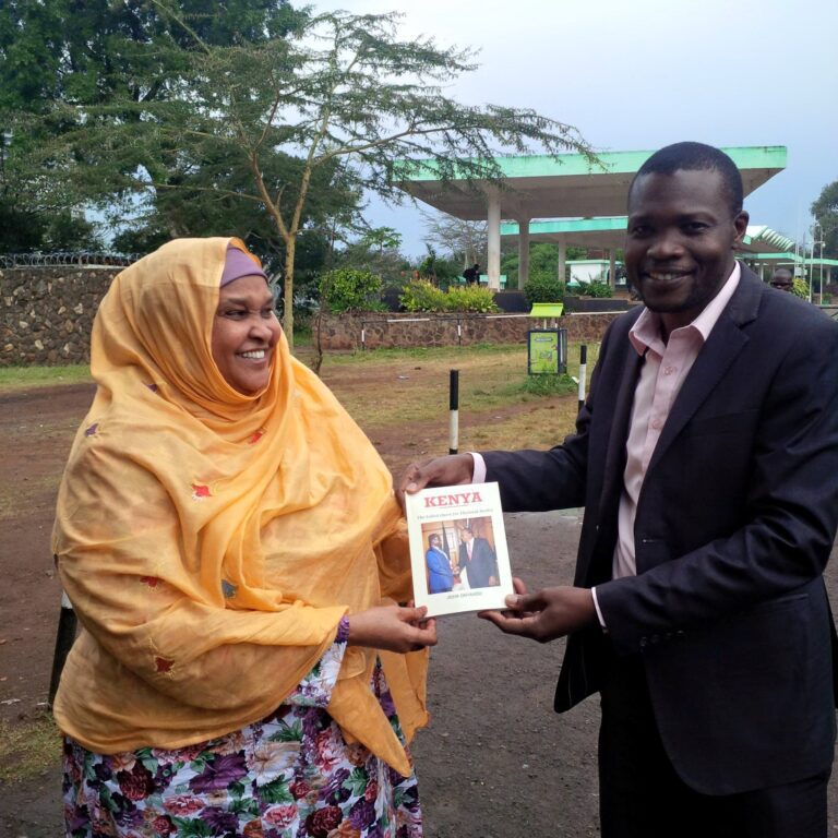 Kenyan journalist, author, and publisher John Onyando presents an autographed copy of his book, KENYA: The Failed Quest for Electoral Justice, to Hon. Fatuma Ibrahim Ali, the first Woman Representative for Wajir County.