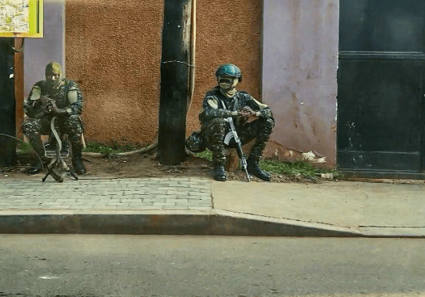 Two Uganda People's Defence Forces (UPDF) soldiers stand guard outside the Nation Media Group Uganda offices in Kampala, one of them manning a mounted machine gun at the entrance. Picture/Courtesy